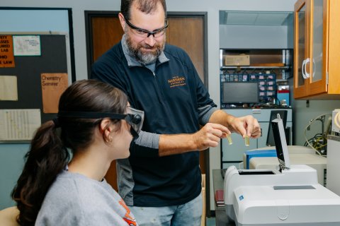 Foto de primer plano de instructores ayudando a estudiantes de la ONU con gafas de laboratorio