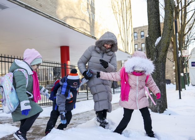Mayra Miranda reúne a sus hijos y a sus compañeros de clase después de que salen de la Academia St. Stanislaus Kostka en West Town el 26 de enero de 2026. Está previsto que la escuela cierre al final del año escolar después de 151 años. (Eileen T. Meslar/Chicago Tribune)