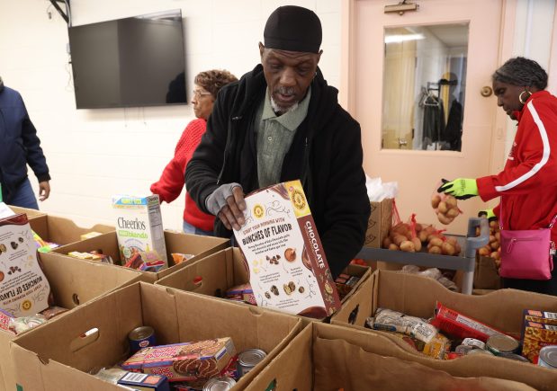 Kenneth Robinson, de 61 años, beneficiario del Programa de Asistencia Nutricional Suplementaria (SNAP), es voluntario en la despensa de alimentos Chosen Tabernacle Bread of Life, empacando alimentos en cajas para su posterior distribución en un hogar de ancianos el 26 de enero de 2026. (Antonio Perez/Chicago Tribune)