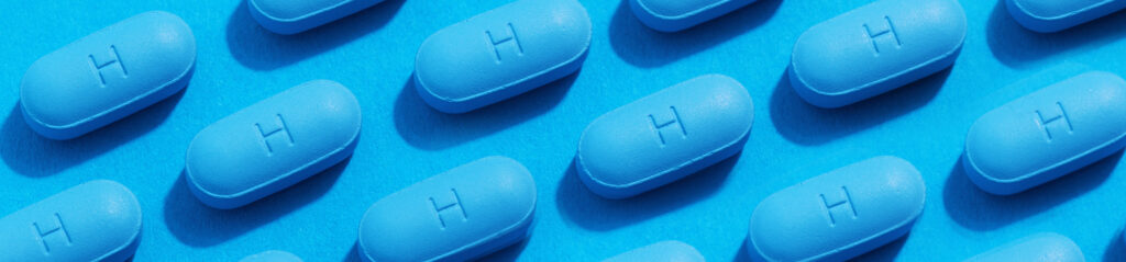 Pastillas PrEP dispuestas en filas sobre un fondo azul