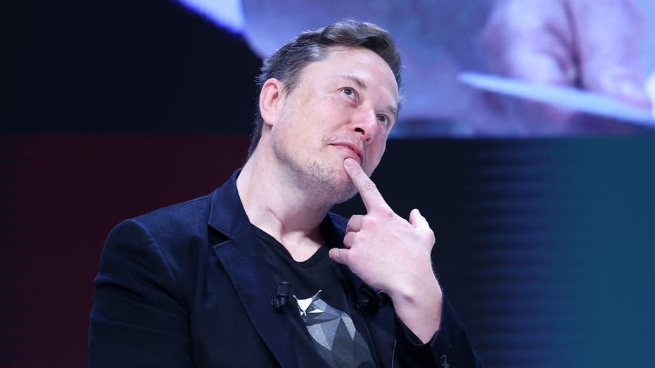 Elon Musk en calma pensativa con un dedo en la barbilla