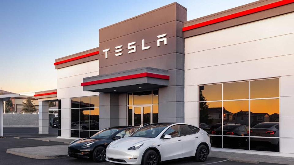 Edificio Tesla con el logo de Tesla y dos Teslas al frente