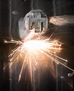 <strong>Una máquina de descarga eléctrica por hilo, o EDM, corta una placa de circuito impresa mediante fabricación aditiva en CAMINO. </strong>(Foto de Craig Fritz) Haga clic en la miniatura para ver la imagen de alta resolución.» class=»wp-image-114139″ data-description=»» data-title=»fabricación aditiva CAMINO» data-caption=»<figcaption class="título-elemento-wp"><strong>Una máquina de descarga eléctrica por hilo o electroerosión corta una placa base que se imprimió mediante fabricación aditiva en CAMINO. </strong>(Foto de Craig Fritz) Haga clic en la miniatura para ver una imagen de alta resolución.</figcaption>»  tamaños=»(ancho máximo: 244px) 100vw, 244px»/><figcaption class=