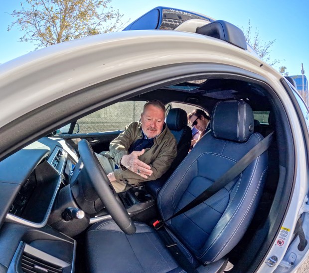 El alcalde de Orlando, Buddy Dyer, y el gerente de políticas del sudeste de Waymo, John Tupps, a la derecha, se preparan para viajar en el vehículo robotaxi totalmente autónomo en el primer día oficial del servicio en Orlando el 24 de febrero de 2026. Orlando se unió a Dallas, Houston y San Antonio para debutar el servicio Waymo el martes, poniendo fin a todos los servicios en EE. UU. (Joe Burbank/Orlando Sentinel)