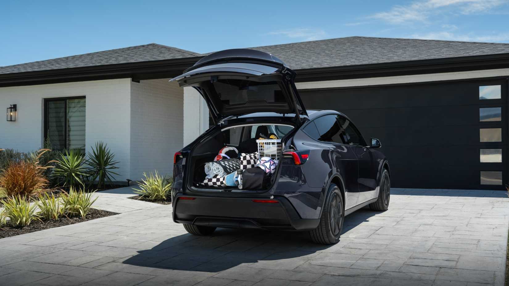 Tesla Model Y Standard estacionado con la puerta abierta